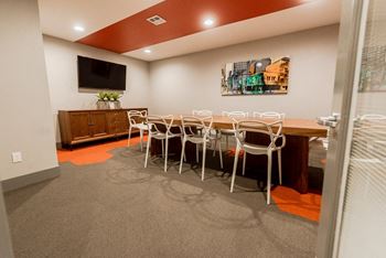 A dining room with a table and chairs and a television